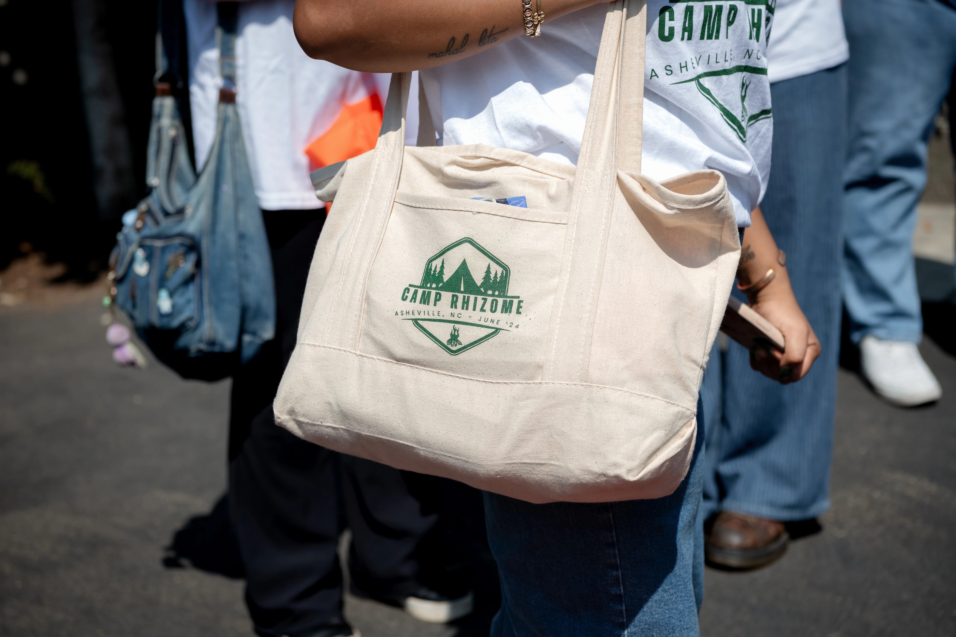 A community member carrying a Camp Rhizome tote bag